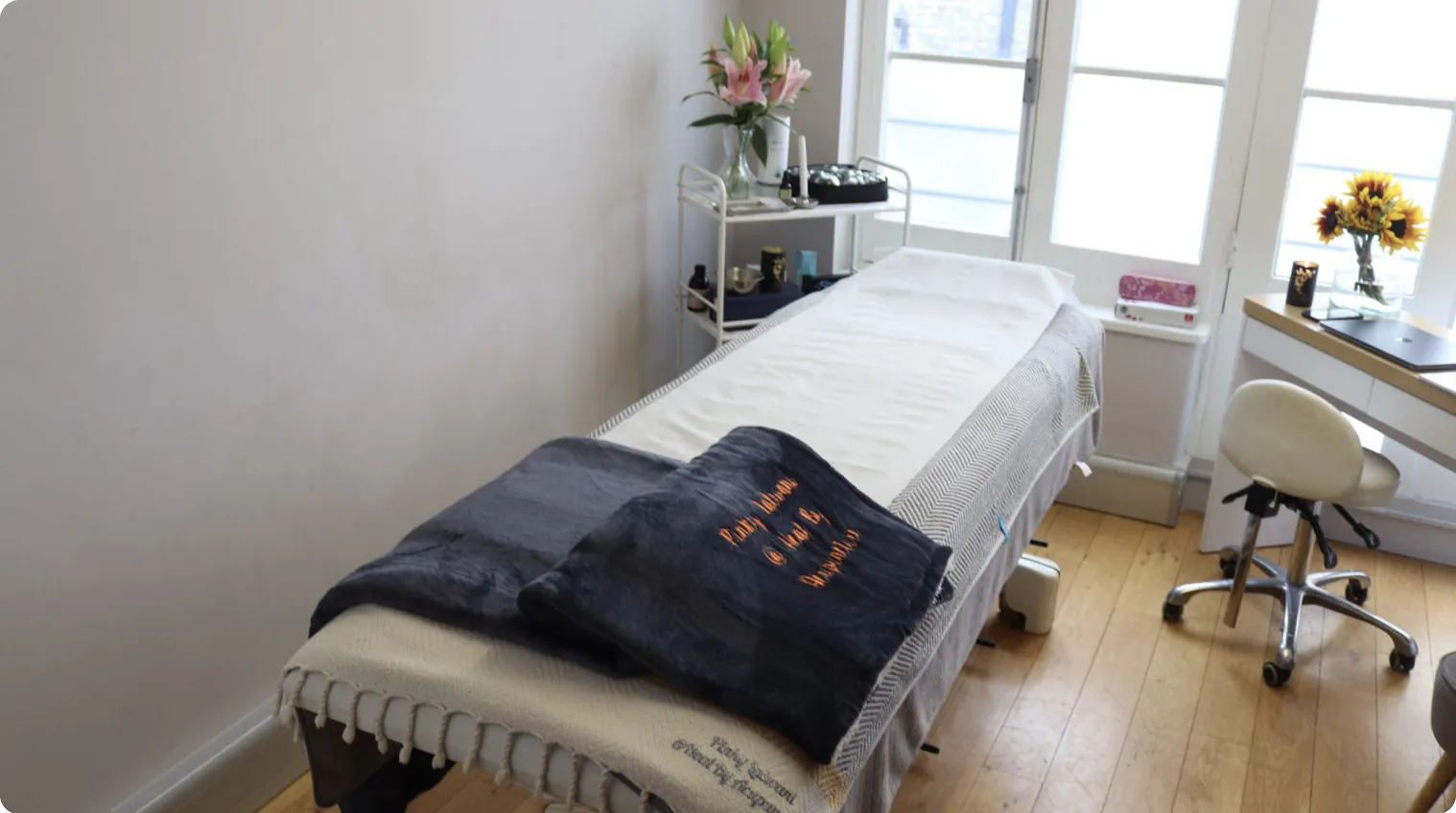 A bright treatment room with a prepared treatment couch