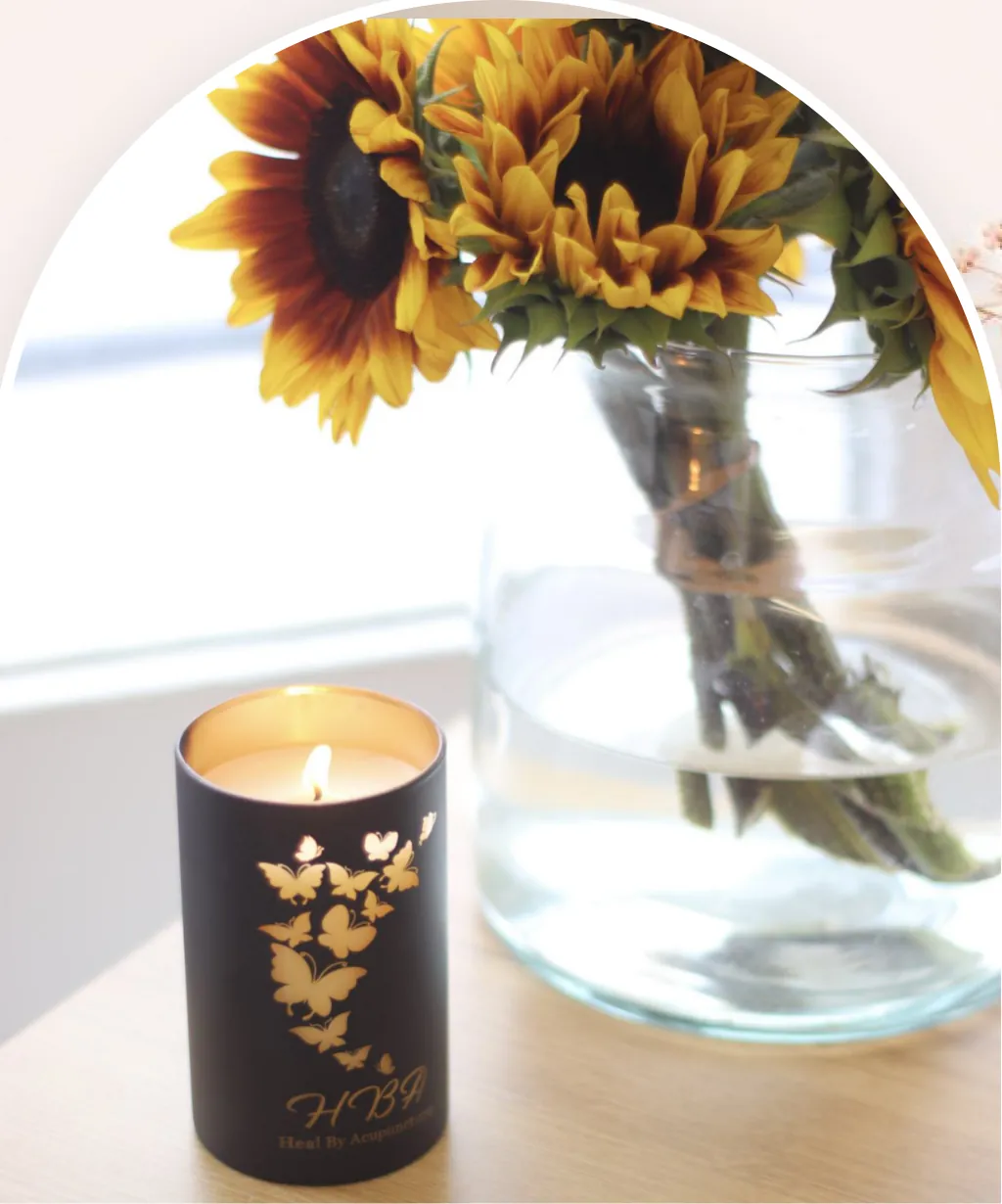 Sunflowers and a Heal By Acupuncture candle in the treatment room