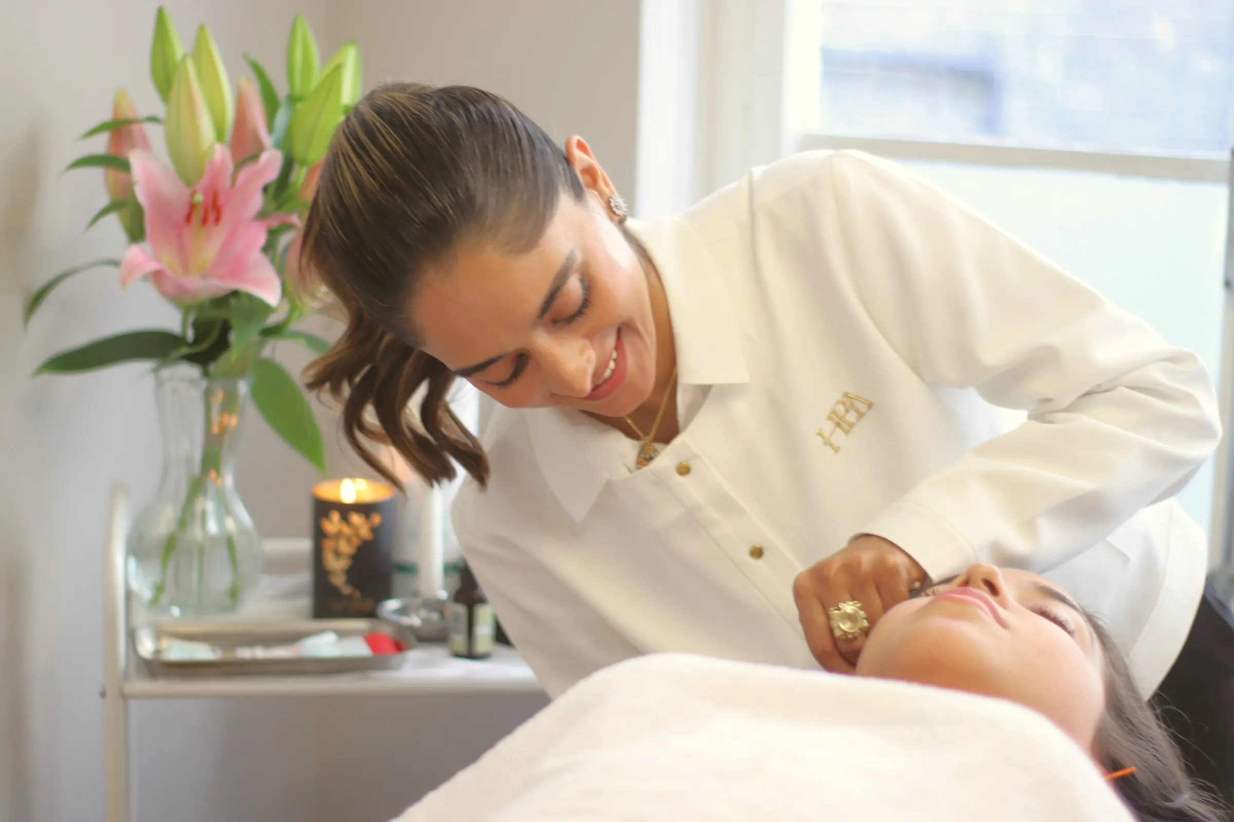 Pinky Lalwani giving a facial acupuncture treatment to a patient at her London clinic