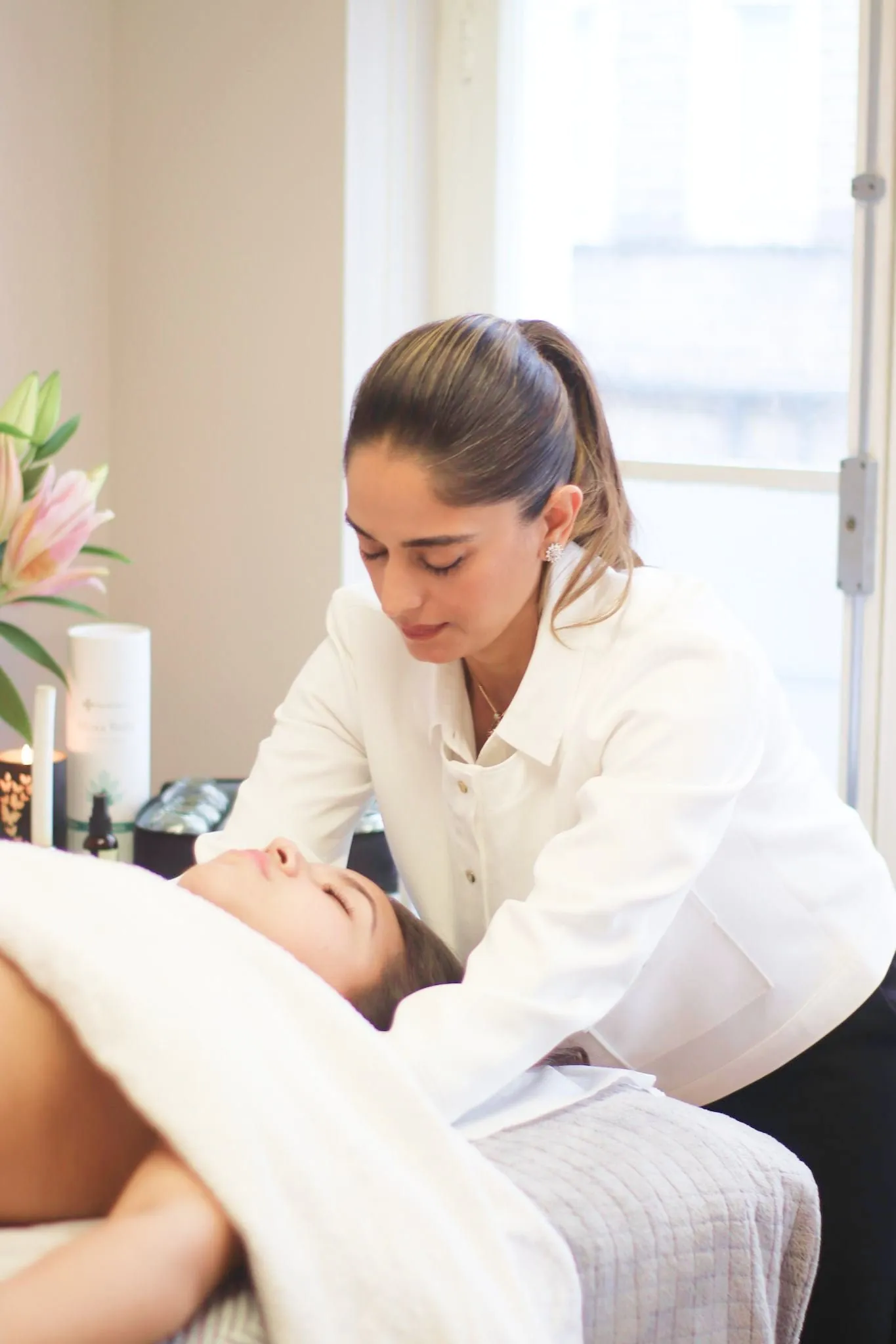 Pinky Lalwani treating a patient lying on a treatment couch