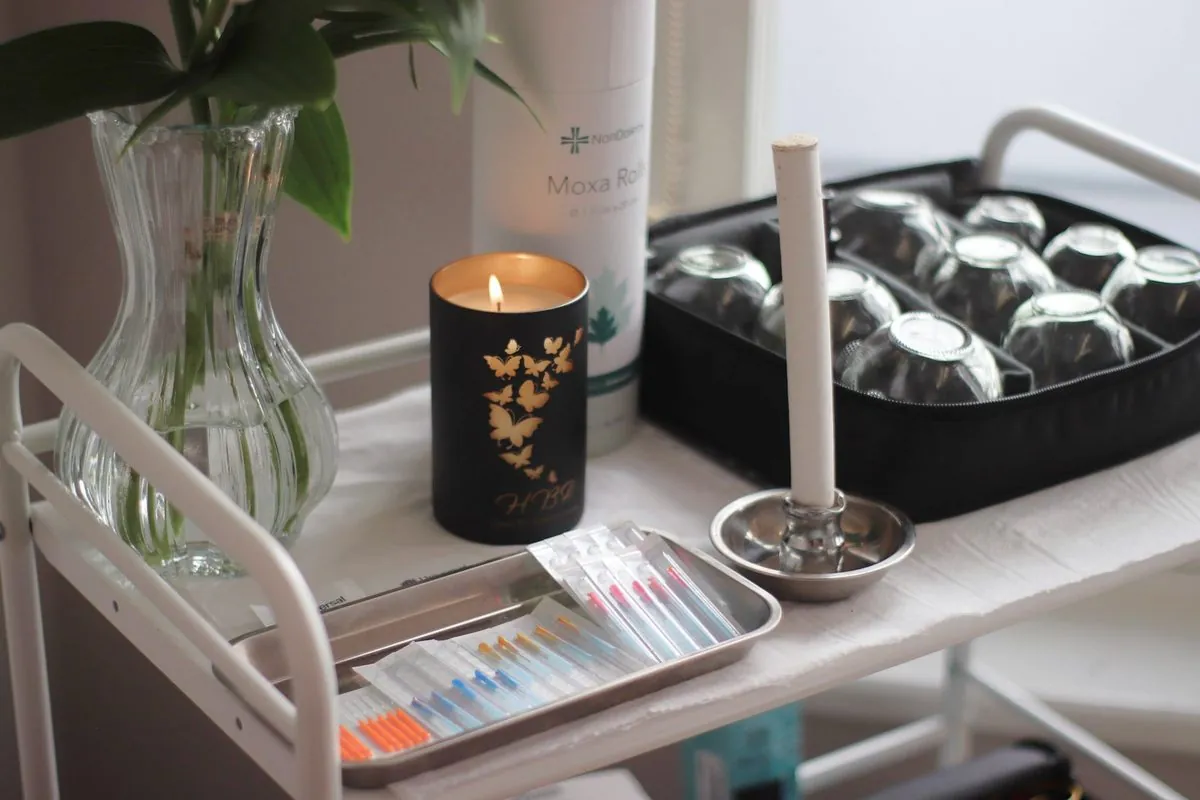 Treatment trolley with acupuncture needles, cups and a candle